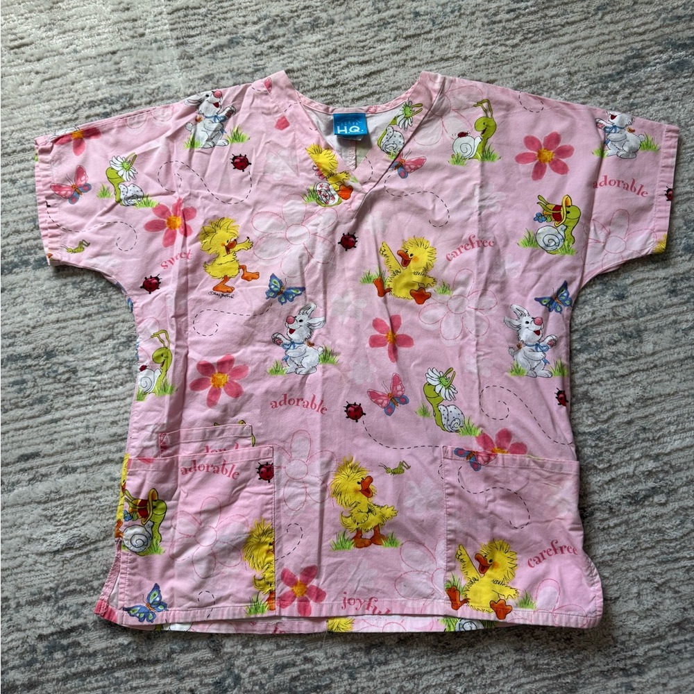 Pink women’s scrub top with fun print.